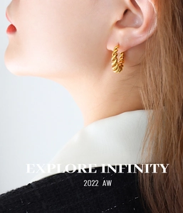 Close-up of golden hollow twisted rope hoop earrings worn on female model's ear