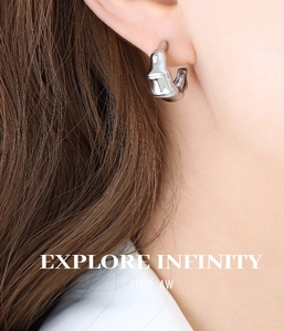 Gros plan de boucles d'oreilles anneaux en bambou poli portées par un mannequin