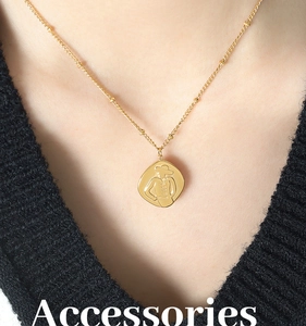 Detail of French embossed portrait pendant necklace in gold finish on female model