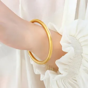 Minimalist 18K gold plated titanium steel matte bangle worn on a female wrist