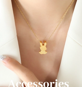Gros plan d'un collier avec pendentif lapin doré délicat porté sur un mannequin chic
