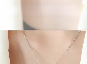 Gros plan d'un collier ras du cou argenté minimaliste porté par un mannequin mode