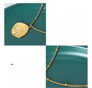 Close-up of 18K gold plated titanium steel necklace with embossed portrait pendant