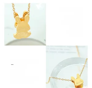 Détail macro d'un pendentif lapin mignon en collier d'acier titane plaqué or 18 carats