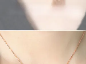Detail of rose gold stainless steel O-chain necklace on model with double happiness pendant