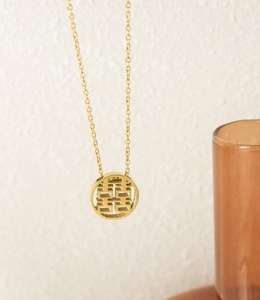 Detailed view of the gold hollow Double Happiness pendant on a fine titanium steel chain
