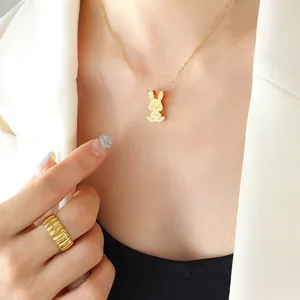 Ensemble collier pendentif lapin doré et bague ondulée porté avec style épuré