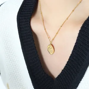 French relief portrait necklace in gold-plated steel featuring a feminine line art pendant
