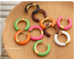 Macro view of colorful enamel glazed gold plated hoop earrings in various vibrant colors