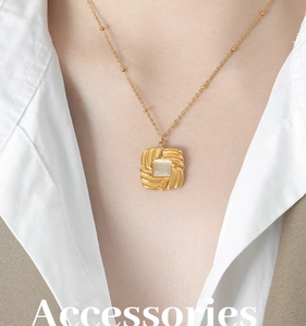 Detailed view of a gold-plated necklace featuring a square cat-eye stone with twisted edges