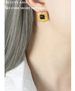 Detail of vintage square gold stud earrings with black stone on model for ear styling