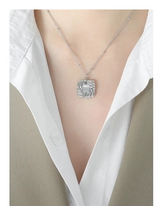 Detail of a square vintage silver necklace featuring swirl texture and cat-eye stone inlay