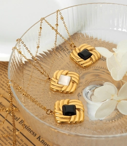 Detail of vintage gold-plated square pendants with inset stones on gold bead chains