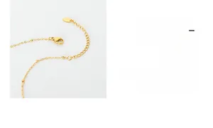 Detail of gold-plated chain with lobster clasp, adjustment links and small gold beads