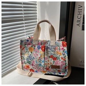Detailed macro view of floral print canvas tote with sturdy woven handles and leather tag