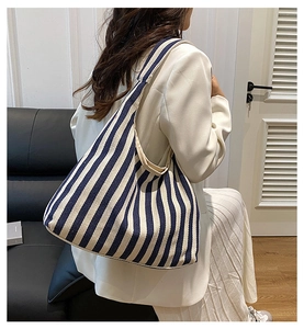 Gros plan d'un sac cabas en toile rayé bleu et blanc montrant la texture et la grande capacité
