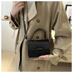 Gros plan d'un mini sac noir structuré doté d'une grande boucle carrée décorative