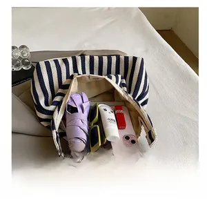 Détail de l'intérieur d'un cabas en toile à rayures bleues montrant un rangement spacieux