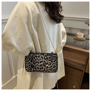 Close-up of leopard print crossbody bag with silver chain strap and metal stud trim