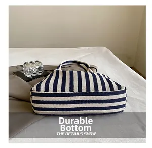 Détail du fond renforcé résistant à l'usure de ce sac fourre-tout en toile à rayures bleues