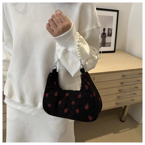 Detail of black corduroy shoulder bag with strawberry embroidery and pearl chain strap