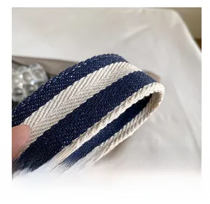 Gros plan sur la bandoulière en toile rayée marine et crème avec texture tissée