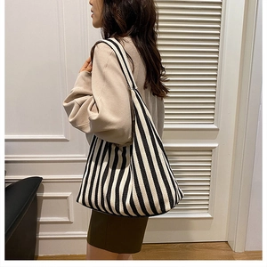 Détail du sac fourre-tout en toile à rayures noires et blanches avec bandoulière large