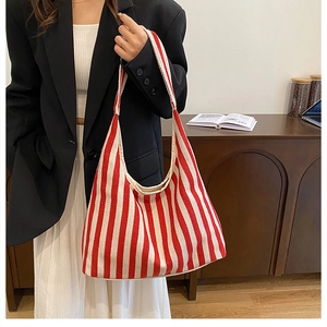 Photo de style d'un sac cabas en toile à rayures rouges et blanches porté par un mannequin