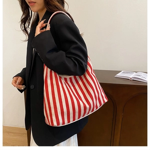 Détail du sac cabas en toile rayé rouge et blanc avec une tenue de mode moderne