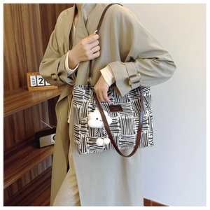 Detail of canvas tote bag with black and white abstract patterns and cloud charm