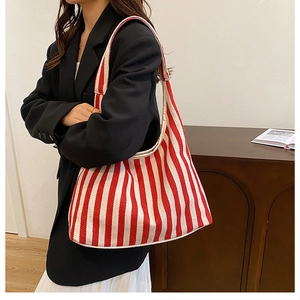 Détail du sac cabas en toile à rayures rouges et blanches montrant la texture et la bandoulière
