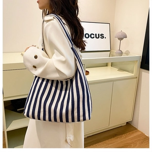 Sac fourre-tout en toile à rayures bleues et blanches montrant le tombé sur modèle