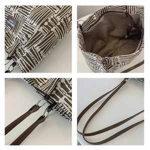 Detail view of canvas tote bag showing geometric patterns, inner zip pocket and hardware