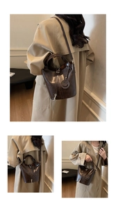 Détail du sac seau en cuir marron avec pendentif sourire et bandoulière réglable