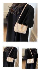 Detail of color-block flap bag featuring a golden metal buckle and adjustable leather strap