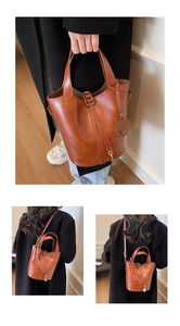 Détail du sac seau rétro beige montrant les coutures et le charme du cadenas