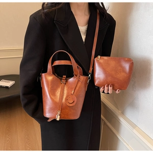 Dettaglio della borsa a secchiello in pelle color caramello con lucchetto dorato
