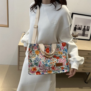 Floral canvas tote bag with adjustable shoulder strap and leather fashion patch detail