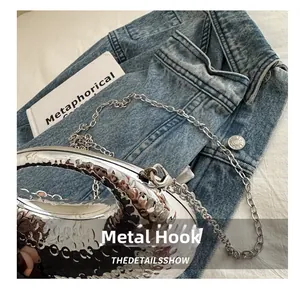 Detail of silver hammered texture evening clutch with sturdy metal hook and chain