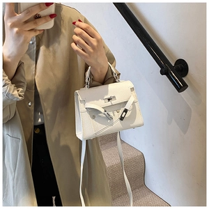 Close-up of white lychee-patterned leather Kelly bag with silver metal clasp