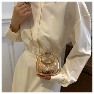 Close-up of a mini gold metal handbag with hammer texture finish and chain strap