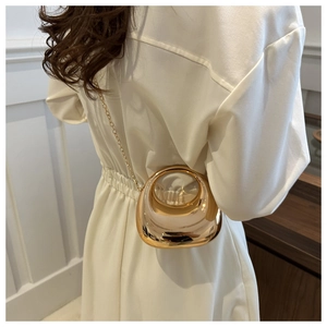 Chic gold metallic mini clutch bag with hollow oval design on a stylish model