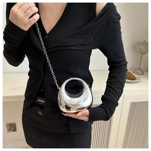 Silver mirror finish crescent mini bag with thin chain strap worn by a model