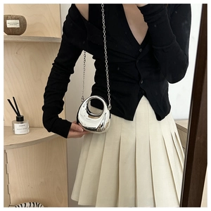 Close-up of a silver mirror finish mini bag with unique hollow round handle and chain