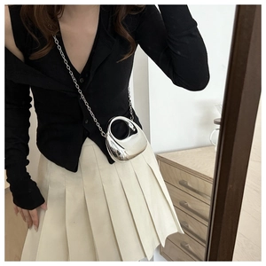 Close-up of a silver mirror-finish egg-shaped mini crossbody bag with a metal chain strap
