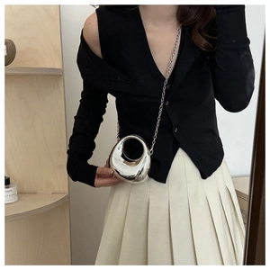 Fashionable silver mirror metal mini egg bag shown on a model with a thin chain strap