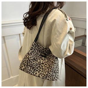 Dettaglio borsa shopper leopardata con tracolla in pelle nera ed etichetta moda