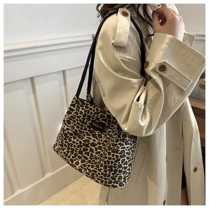 Dettaglio della borsa tote leopardata con cinturini neri indossata su un trench beige