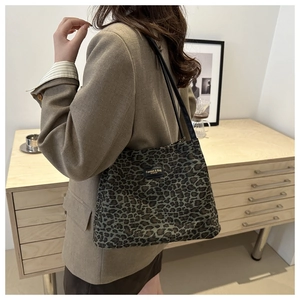 Dettaglio ravvicinato della borsa tote leopardata con etichetta fashion e sottili manici neri