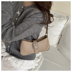 Close-up of a khaki matte leather underarm bag with a vintage silver square buckle detail